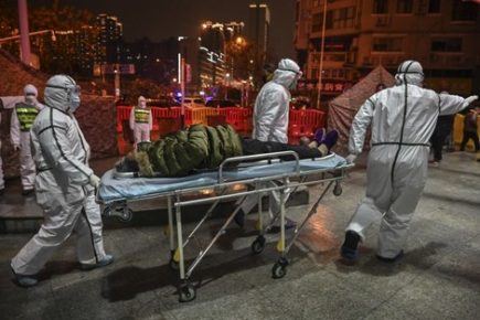 Medical staff members wearing protective clothing to help stop the spread of a deadly virus which began in the city, arrive with a patient at the Wuhan Red Cross Hospital in Wuhan on January 25, 2020. - The Chinese army deployed medical specialists on January 25 to the epicentre of a spiralling viral outbreak that has killed 41 people and spread around the world, as millions spent their normally festive Lunar New Year holiday under lockdown. (Photo by Hector RETAMAL / AFP)